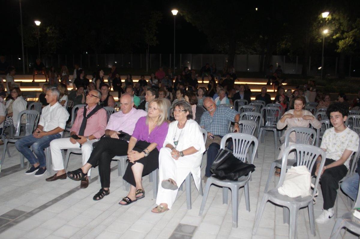 Κάτοικοι και επισκέπτες τραγουδούν και χειροκροτούν στη διάρκεια της συναυλίας.